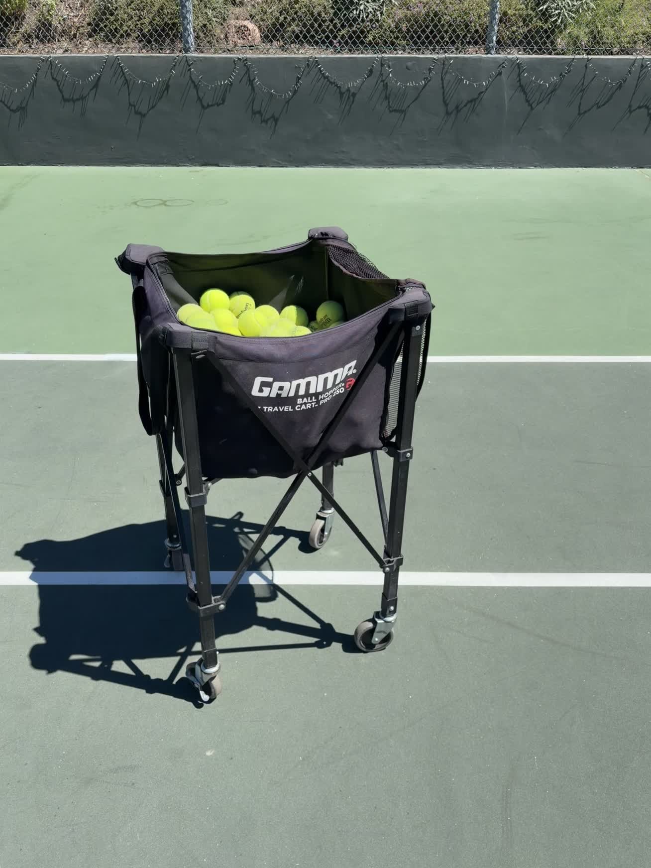 Tennis ball cart stocked for junior tennis training drills on a Los Angeles court