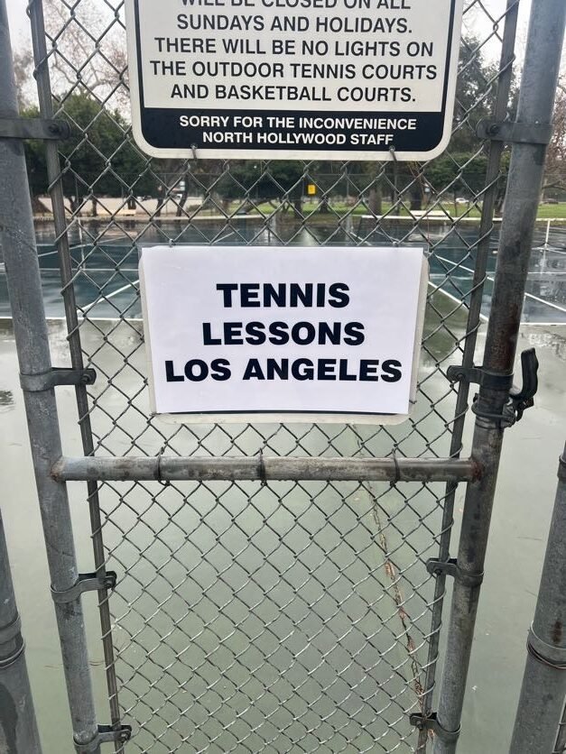 Tennis Lessons Los Angeles sign at an outdoor court used for competitive tennis training
